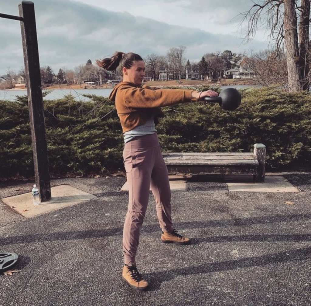 young woman working out with a calisthenics personal trainer on the bike path in rockford, il